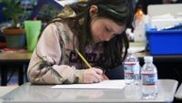 A girl stuent is working on her paperwork.