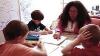 Teacher and a group of students are working together in a classroom.