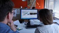 Teacher and a student looking at a design project on the computer.