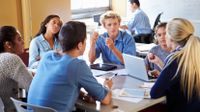 High school students discussing advertisements in a group in the classroom