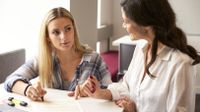 Teacher helping high school girl with an assignment.