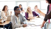 Teacher talking to a class of engaged high school students.