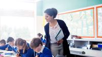 Female teacher with her elementary school students in the classroom.