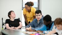 Special education teacher working with high school students with various abilities