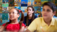 Smart Girl Listening to Teacher At School