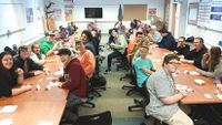 A high school class at Compass Academy sitting around banquet tables.