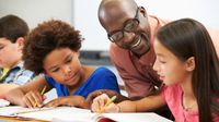 Teacher helping students with project-based learning assignment