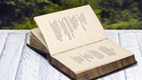Antique book of poetry sitting on picnic table