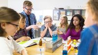 A group of elementary school students working on a science experiment in the classroom.