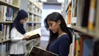 Two high school students reading in the library