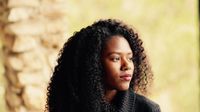 A woman looks off into the distance, contemplating