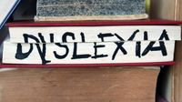 The word "dyslexia" written across the pages of a closed book