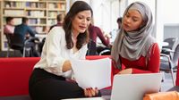 A teacher and a principal discuss the teacher's evaluation in the school library