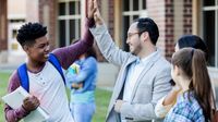 A teacher and a student high-fiving each other