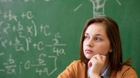 A teenage girl sitting in front of a blackboard with math formulas written on it, looking thoughtful