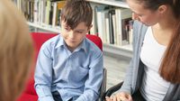 Young boy and his mother having a conference with his teacher