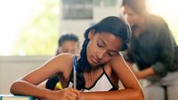 A middle school student writing in class