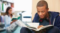 Two high school students reading novels in the library