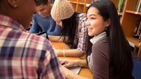 A group of students working on an essay in the library together