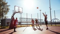 Four men playing basketball. One is shooting a free throw.