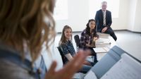 A teen girl speaking in front of her classmates and teacher in a mock trial