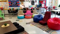 A flexible classroom with colorful, chairs, tables, carpets, and posters