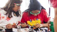 Two middle school students working on a robotics project