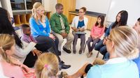A group of parents, teachers, and students talking in a circle