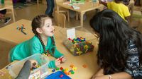 Preschool student works with her teacher in class
