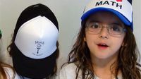 Three young girls are standing beside each other wearing hats that say, "I heart math."