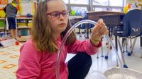 photo of a student examining a science project