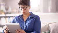 photo of a woman reading on a tablet computer