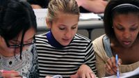 photo of three young women working on a project together