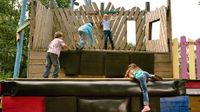 Four children climbing on a play structure