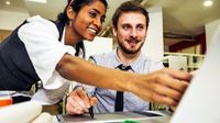 Two happy adults working together at a laptop