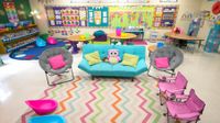 A colorful classroom with couches, collapsible desks, and scoop chairs