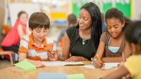 teacher flanked by two students working