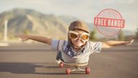 Photo of a boy lying on a skateboard pretending he's flying.