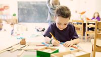 young boy in school working alone
