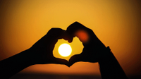 Hands forming a heart with the sun in the middle