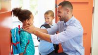 A father gets his two kids ready to head off to school.