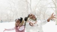 photograph of two students playing in the snow