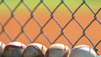 Photo of baseballs against a fence