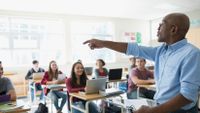 photo of a teacher in front of students in a classroom