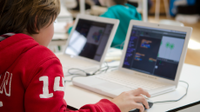 An elementary student working on a laptop