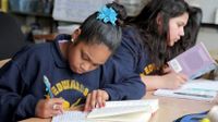 Two girls reading and writing