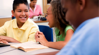 A group of elementary school children in conversation and smiling
