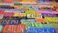 A chalkboard covered with student names in bright colors.