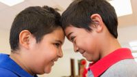 Two boys look into each other's eyes, a technique that builds empathy.