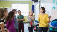 A teacher confidently explains a concept to students.
